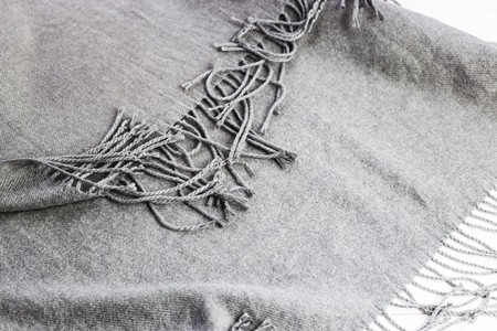Background texture of the crumpled gray winter fashionable female scarf. On a white wooden tableの写真素材