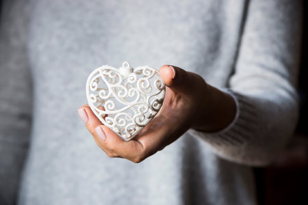 White openwork heart in women's hands - valentine's day concept