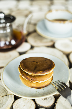Pancakes with chocolate inside on a wooden table of log cabins. Rustic style. Concept of homemade foodの写真素材