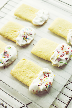 Cookies in the form of Easter cakes, decorated with whipped whites with a multicolored powder. Easter dishes and decorations. Holiday spring conceptの写真素材