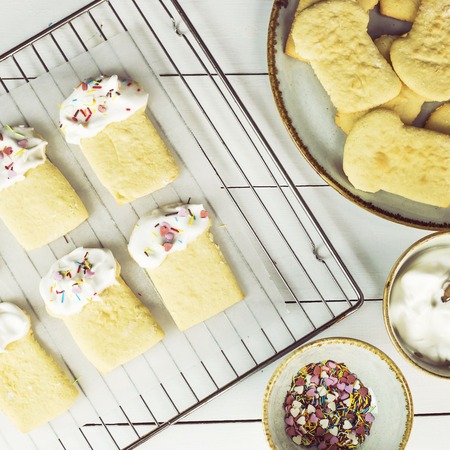Cookies in the form of Easter cakes, decorated with whipped whites with a multicolored powder. Easter dishes and decorations. Holiday spring conceptの写真素材