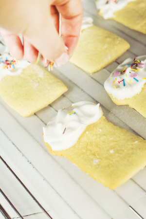 Cookies in the form of Easter cakes, decorated with whipped whites with a multicolored powder. Easter dishes and decorations. Holiday spring conceptの写真素材