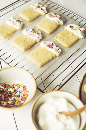 Cookies in the form of Easter cakes, decorated with whipped whites with a multicolored powder. Easter dishes and decorations. Holiday spring conceptの写真素材