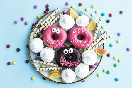 Sweet unhealthy food on a plate - donuts, meringue, sticks, marmalade, chocolate grains. Junk food conceptの写真素材
