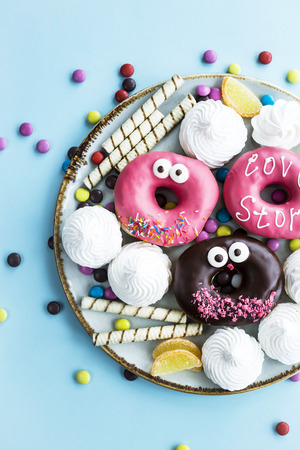 Sweet unhealthy food on a plate - donuts, meringue, sticks, marmalade, chocolate grains. Junk food conceptの写真素材