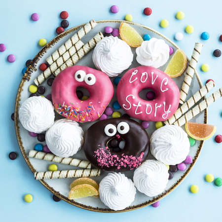 Sweet unhealthy food on a plate - donuts, meringue, sticks, marmalade, chocolate grains. Junk food conceptの写真素材