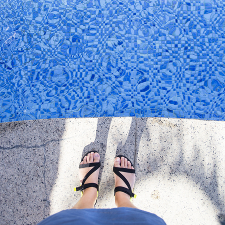 Female feet in summer sandals near the poolの写真素材