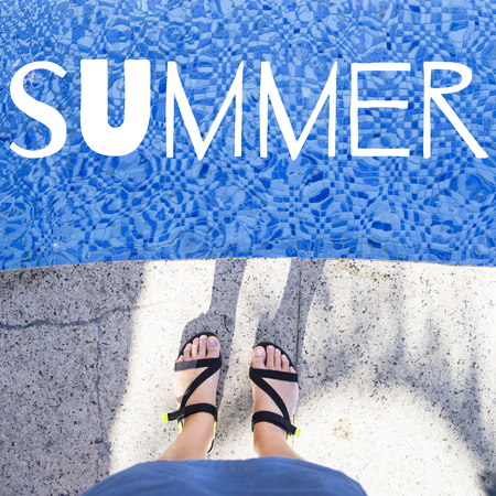 Female feet in summer sandals near the pool. Summer concept. The word summer is written on the photoの写真素材