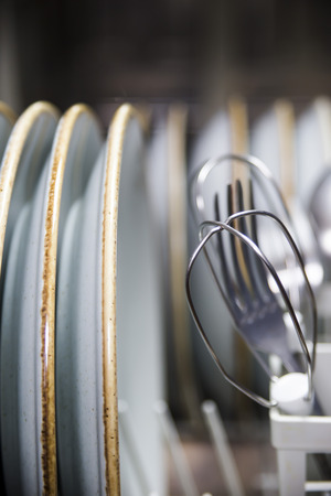 Clean cutlery in the dishwasher. Home equipment. Work at home conceptの写真素材