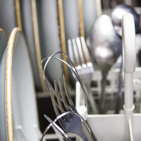 Clean cutlery in the dishwasher. Home equipment. Work at home conceptの写真素材