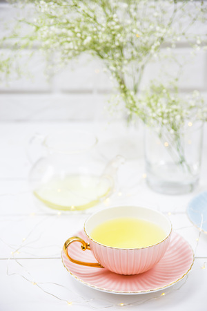Delicate vintage cups of pink and blue with tea among the white dried flowers of gypsophila. Home interior and still life conceptの写真素材