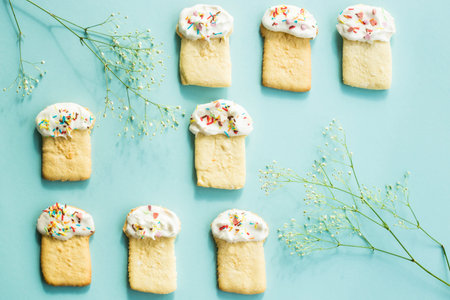 Cookies in the form of Easter cakes on a blue background among the flowers of gypsophila