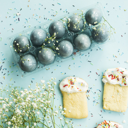 Cookies in the form of Easter cakes and blue-colored Easter eggs among the flowers of gypsophila. Spring holiday conceptの写真素材