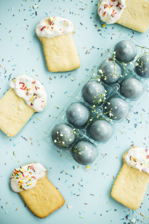 Cookies in the form of Easter cakes and blue-colored Easter eggs among the flowers of gypsophila. Spring holiday conceptの写真素材
