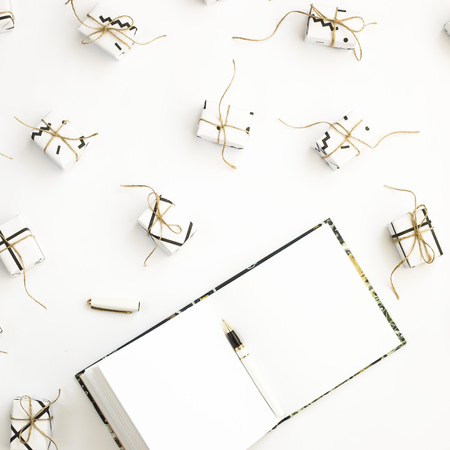 Notepad among small minimalistic gifts on a white background. Flat lay, top viewの写真素材