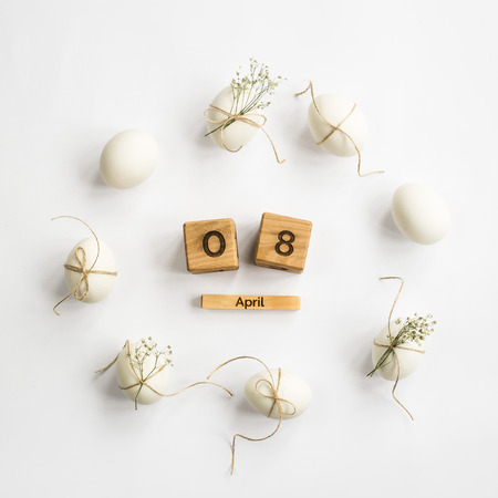 Easter white eggs are minimalistically decorated with twine and gypsophila. With a wooden calendar. 08 April 2018. Easter. Top view, flat layの写真素材