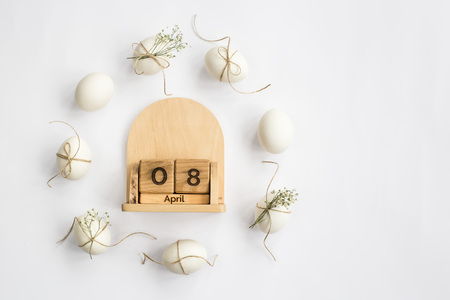 Easter white eggs are minimalistically decorated with twine and gypsophila. With a wooden calendar. 08 April 2018. Easter. Top view, flat layの写真素材