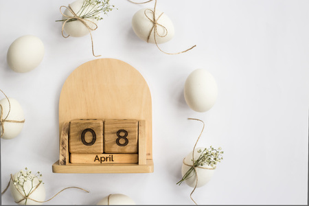 Easter white eggs are minimalistically decorated with twine and gypsophila. With a wooden calendar. 08 April 2018. Easter. Top view, flat layの写真素材