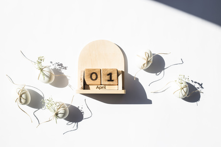 Wooden calendar - April 1 - the date of the Catholic Easter in 2018. Next to the white minimalistic Easter eggs. Flat lay, top viewの写真素材