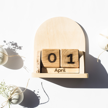 Wooden calendar - April 1 - the date of the Catholic Easter in 2018. Next to the white minimalistic Easter eggs. Flat lay, top viewの写真素材