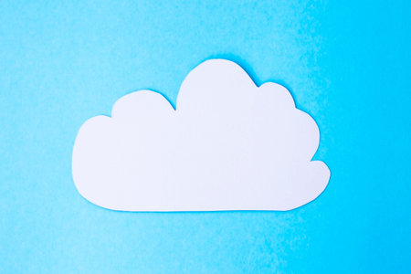A gray cloud on a blue paper background. Minimalism. Conept of cloud-based files. Cloudy weather