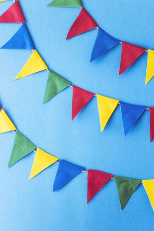 Multi-colored flags decoration on a bright blue background. Summer background festival conceptの写真素材