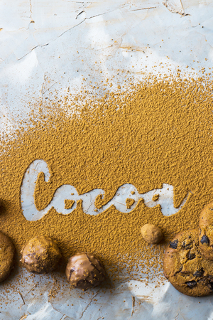 The word cocoa is written on the background of cocoa powder next to chocolate biscuits and candy. I love chocolate conceptの写真素材