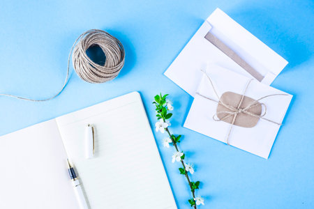 Creative workplace with a notebook, twine and conjectures on a blue background. Spring workplace...