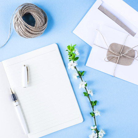 Creative workplace with a notebook, twine and conjectures on a blue background. Spring workplace conceptの写真素材