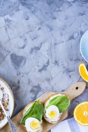 Healthy hearty breakfast - muesli, sandwich with egg, coffee, orange and juice. Copyspaceの写真素材