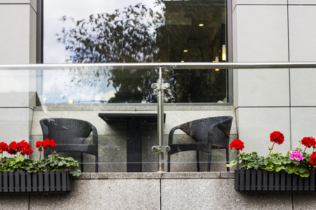 Red geranium in flowerpots on the terrace of a modern business centerの写真素材