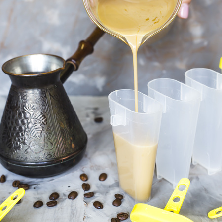 The process of cooking coffee ice cream. Homemade summer cooling dessert. Among coffee beans on a gray tableの写真素材