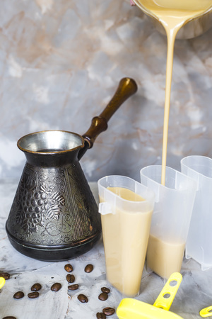 The process of cooking coffee ice cream. Homemade summer cooling dessert. Among coffee beans on a gray tableの写真素材