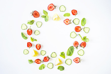Strawberries, lemon, cucumber and mint are lined in the form of a wreath on a white background. Detox Concept. Top view, flat layの写真素材