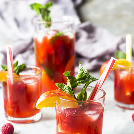 Light summer refreshing drink with fruits and berries - sangria. In glasses on a gray tableの写真素材
