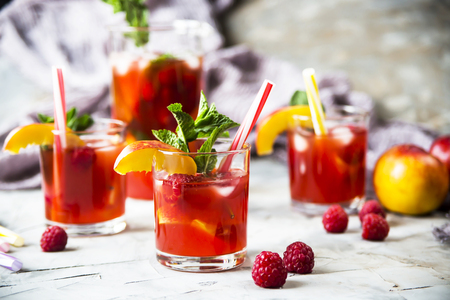 Light summer refreshing drink with fruits and berries - sangria. In glasses on a gray tableの写真素材