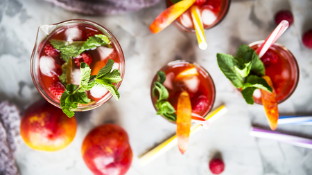 Light summer refreshing drink with fruits and berries - sangria. In glasses on a gray table. Top view, flat layの写真素材