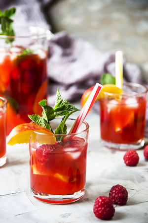 Light summer refreshing drink with fruits and berries - sangria. In glasses on a gray tableの写真素材