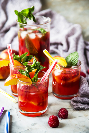 Light summer refreshing drink with fruits and berries - sangria. In glasses on a gray tableの写真素材