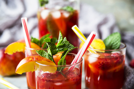 Light summer refreshing drink with fruits and berries - sangria. In glasses on a gray tableの写真素材