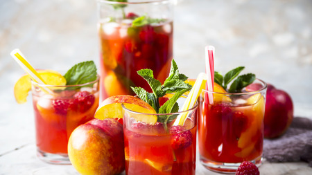 Light summer refreshing drink with fruits and berries - sangria. In glasses on a gray tableの写真素材