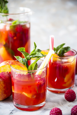 Light summer refreshing drink with fruits and berries - sangria. In glasses on a gray tableの写真素材