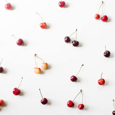 Yellow and dark red berries of a sweet cherry on a white background. Summer Pattern. Top view, flat layの写真素材