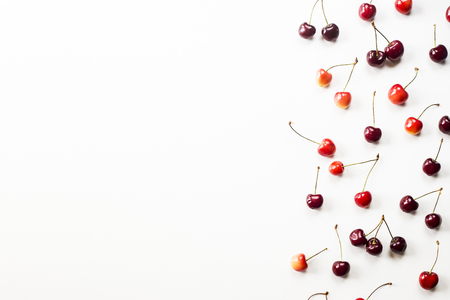 Yellow and dark red berries of a sweet cherry on a white background. Summer concept. Top view, flat lay, copyspaceの写真素材