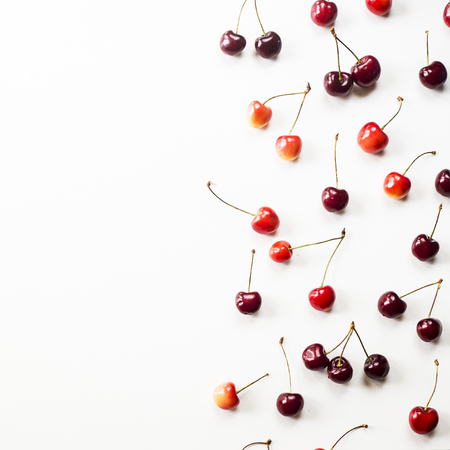 Yellow and dark red berries of a sweet cherry on a white background. Summer concept. Top view, flat lay, copyspaceの写真素材
