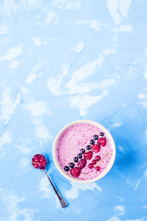 Berry smoothies with currants and raspberries on a bright blue background. Summer healthy snack. Copy space. Top viewの写真素材