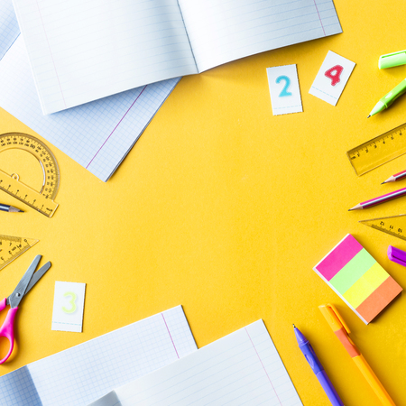 Writing-books, pens, pencils, numbers and rulers on a yellow background. Accessories for study. Mathematics, geometry, algebra. Top view, flat lay, copy spaceの写真素材