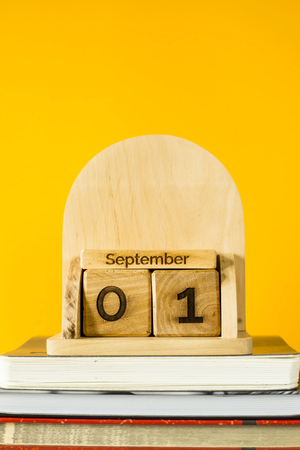 September 1 on a wooden calendar among textbooks to study on a yellow background. Back to school conceptの写真素材