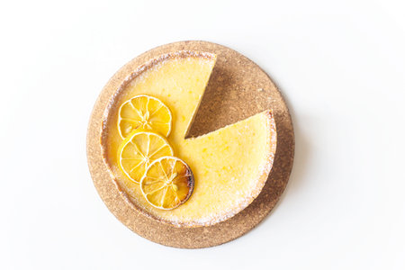 Lemon tart with dried lemons as a decoration from above on a white background. Home baking autumn...