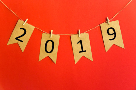 2019 year written on craft flags on a red background. New Years offensive conceptの写真素材
